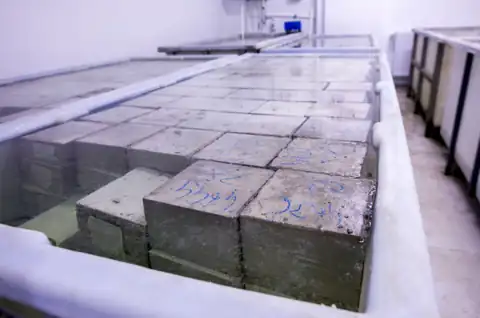 Concrete test cubes immersed in a laboratory curing water tank before compressive strength testing