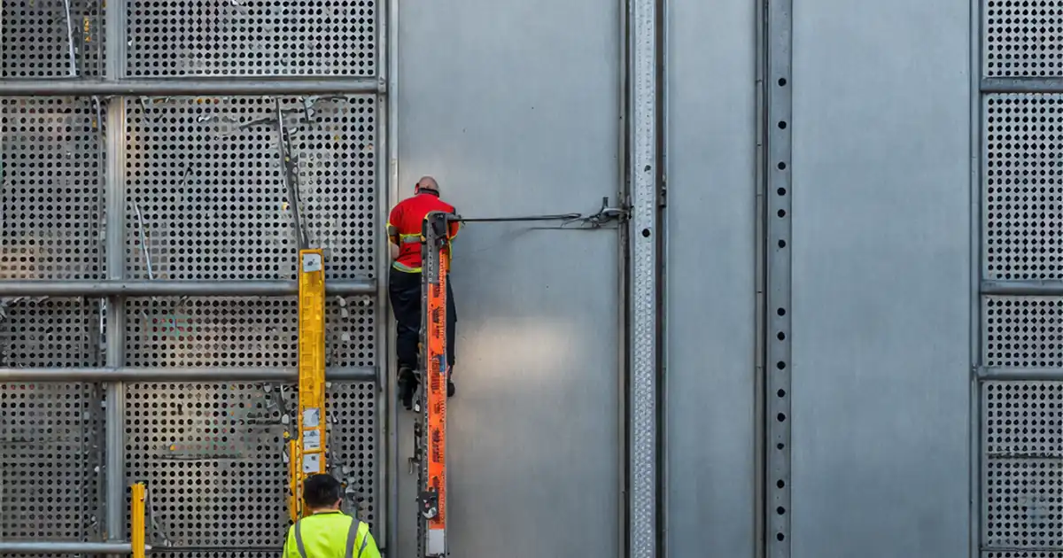 Inspect perforated metal façade panel installation – framing image